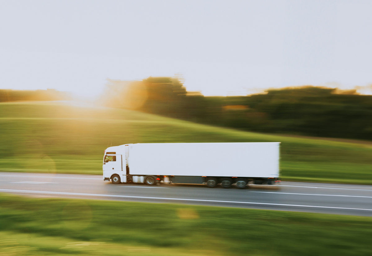 A white delivery truck on the road, representing mattress shipping from Rimrock Mattress Co. in Billings, Montana.